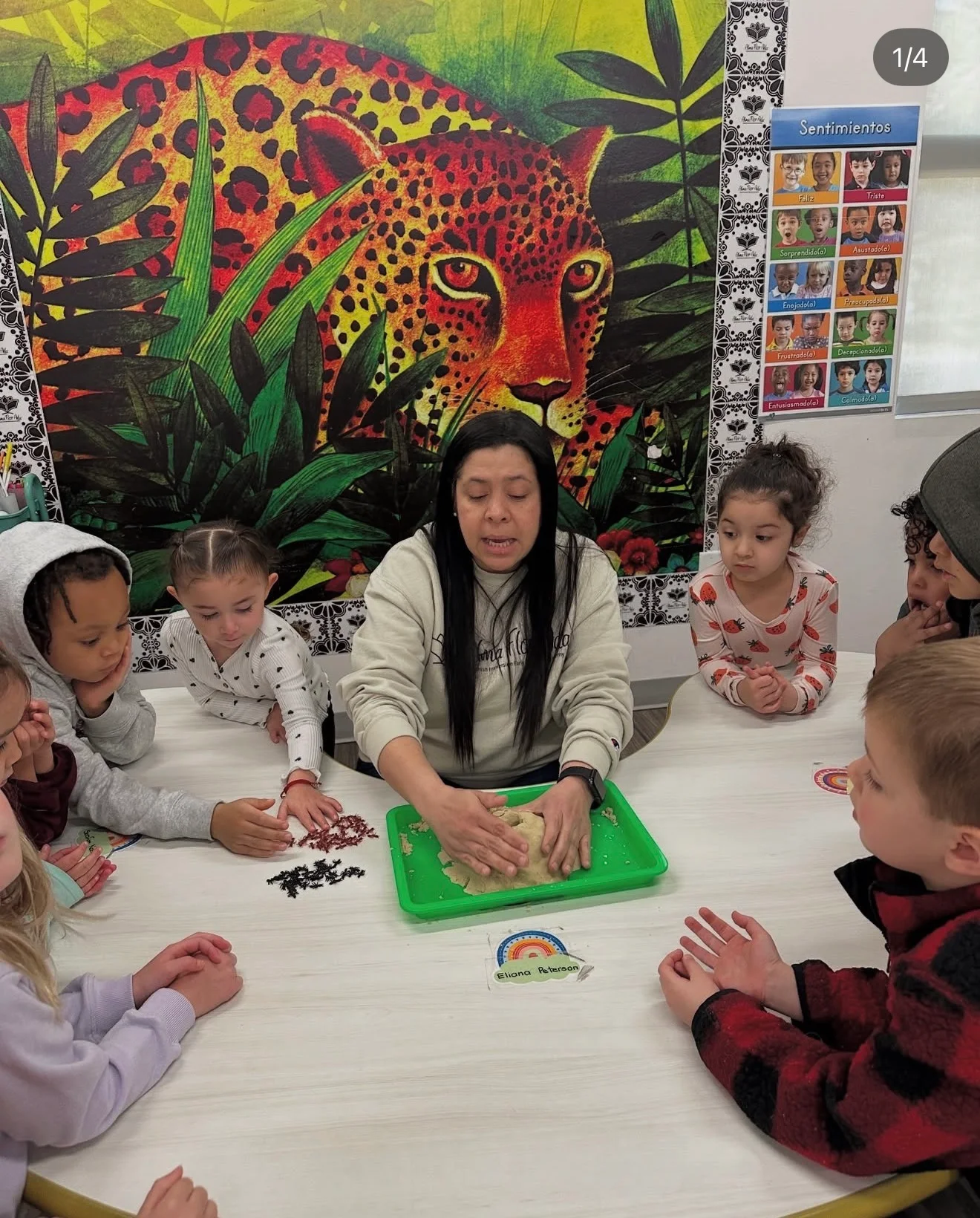 An AFA teacher and children exploring a hands-on activity together around a classroom table